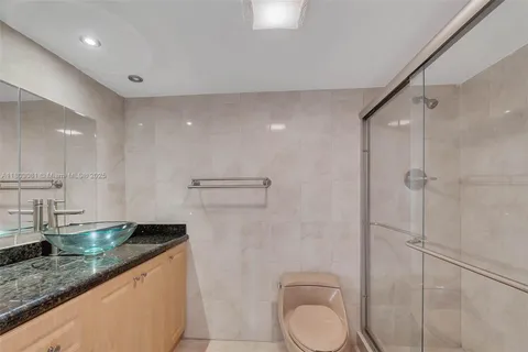 a bathroom with a granite countertop sink a toilet and shower