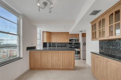 a kitchen with stainless steel appliances granite countertop a stove and cabinets