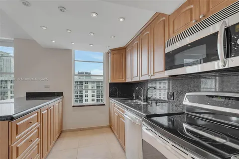 a kitchen with stainless steel appliances granite countertop a sink and a stove