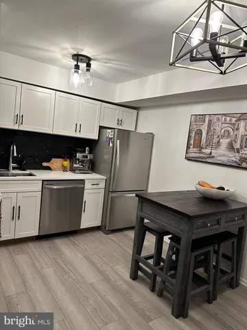 a kitchen with a table chairs refrigerator and sink