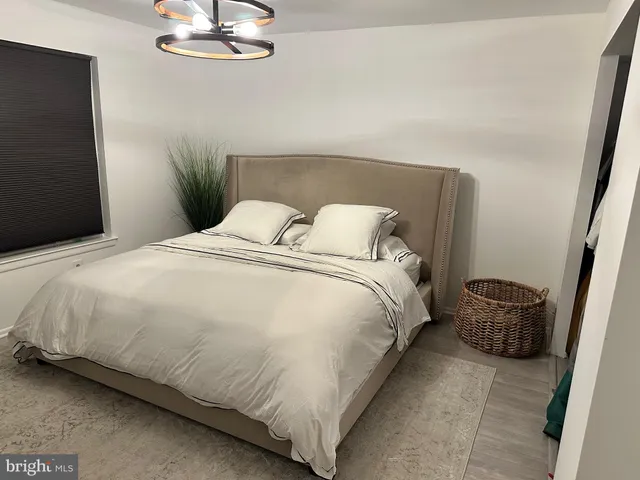 a large bed sitting in a bedroom next to a window