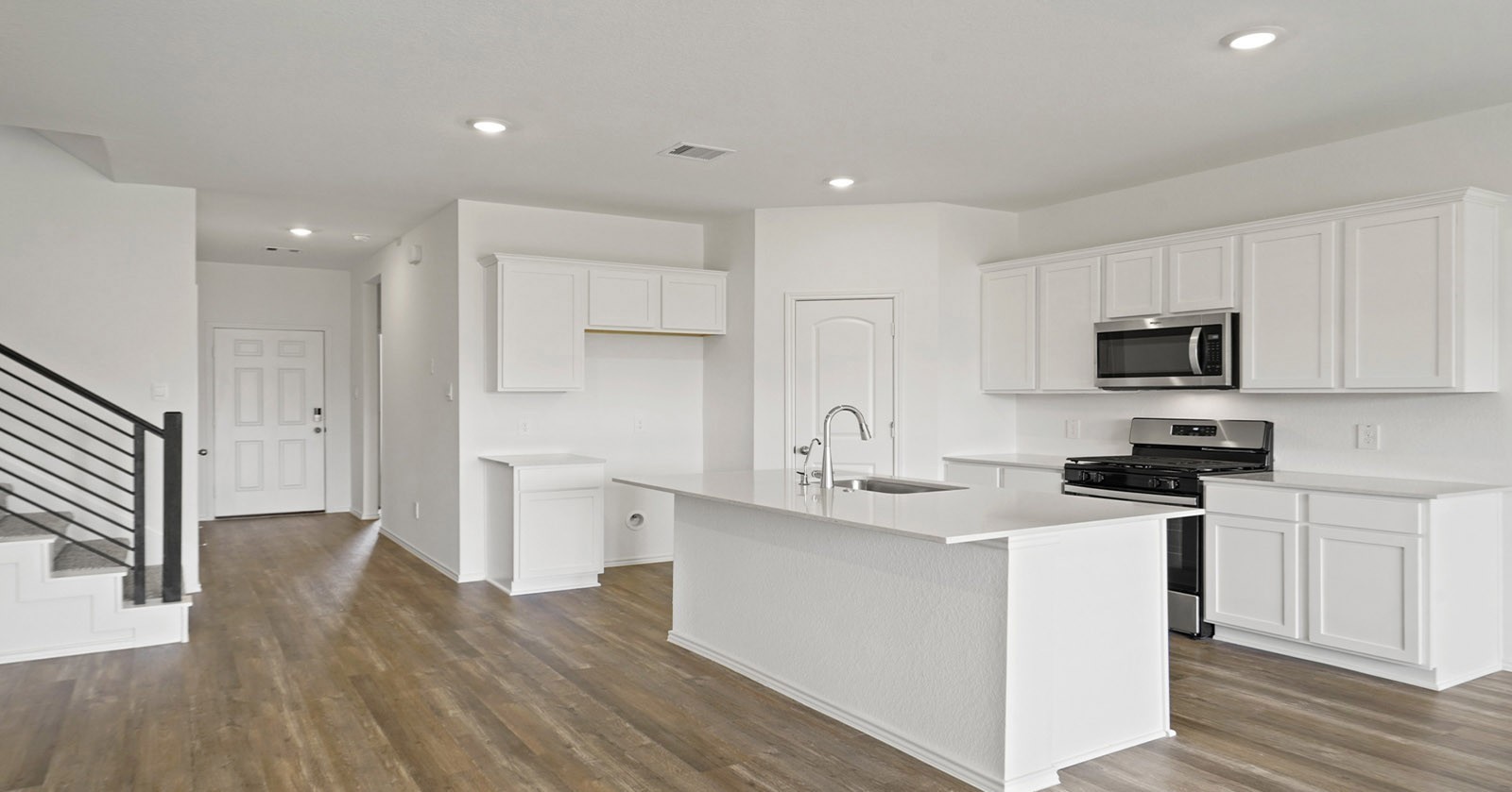 31722 Melkridge Road Fulshear, TX 77441 - Photo 7 of 20 a kitchen with stainless steel appliances granite countertop a sink stove refrigerator and white cabinets with wooden floor