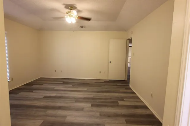 a view of an empty room with wooden floor