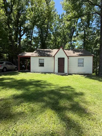 a front view of a house with yard and green space