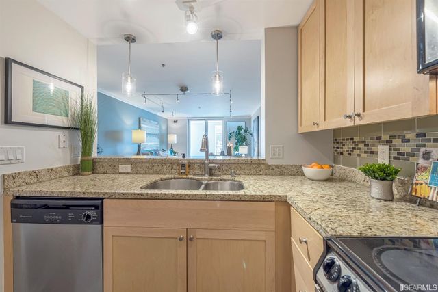 a kitchen with granite countertop a stove sink and microwave