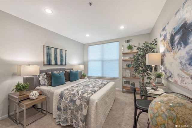 a bedroom with a large bed and a chandelier