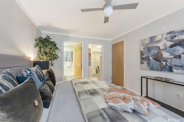 a bedroom with a large bed and a chandelier