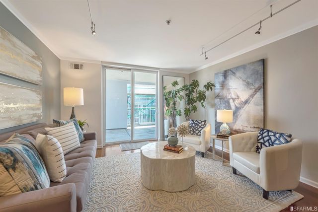 a living room with furniture and a wooden floor