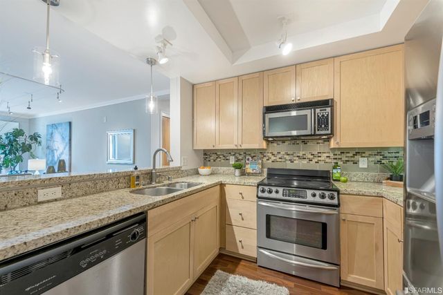 a kitchen with stainless steel appliances granite countertop a stove a sink and a microwave