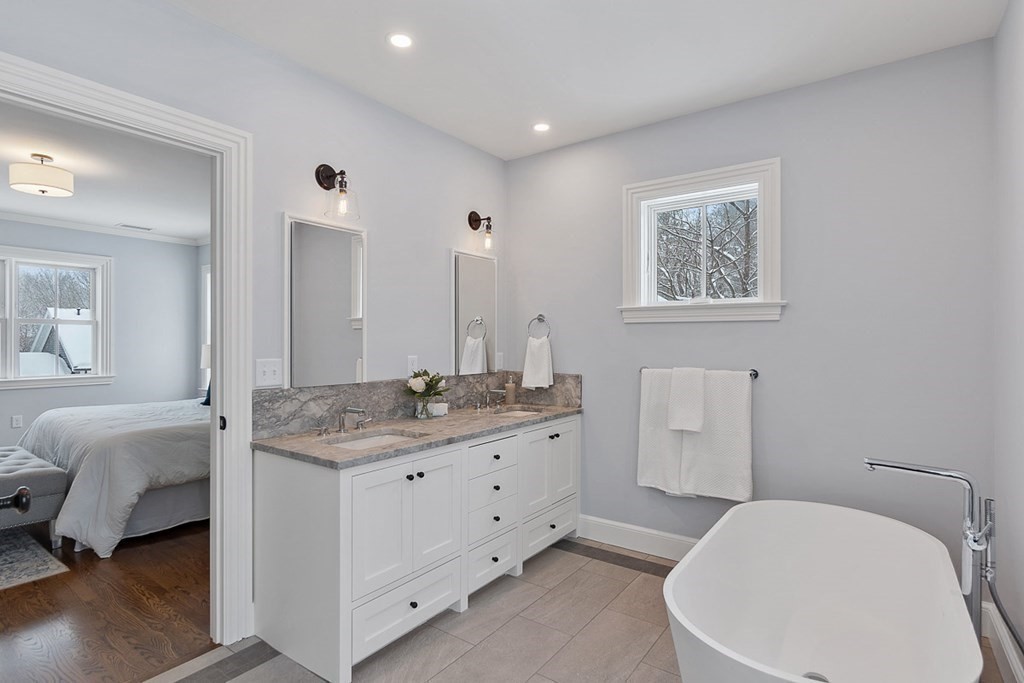 46 Hubbard Street Concord, MA 01742 - Photo 18 of 24 a spacious bathroom with a granite countertop sink a toilet and a mirror