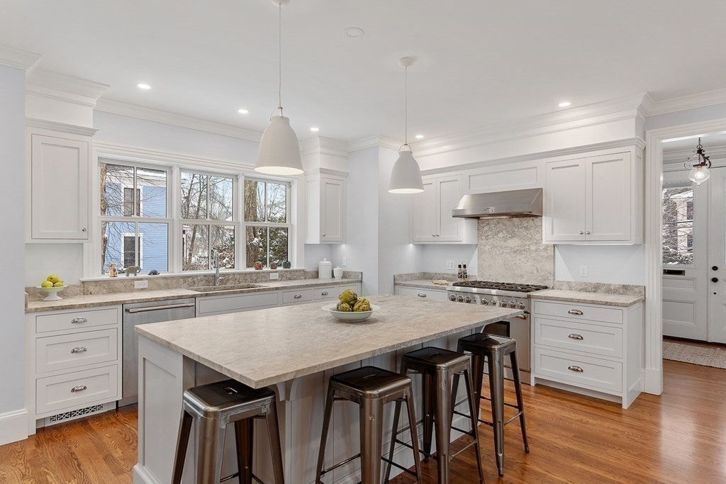 46 Hubbard Street Concord, MA 01742 - Photo 4 of 24 a kitchen with granite countertop white cabinets stove and center island