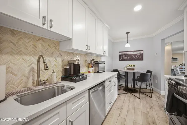 a kitchen with granite countertop a sink a stove and cabinets