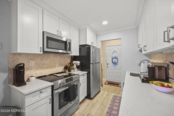 a kitchen with stainless steel appliances a stove microwave and refrigerator