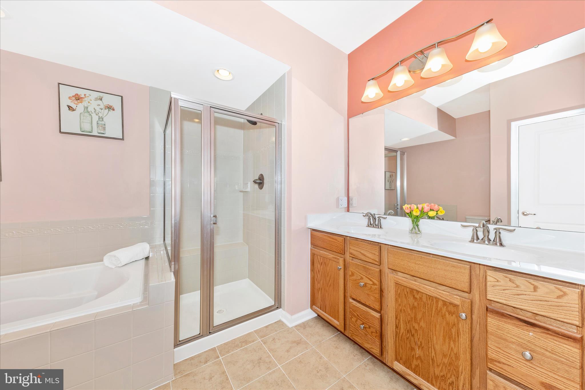 5043 Small Gains Way Frederick, MD 21703 - Photo 18 of 44 a spacious bathroom with a double vanity sink a mirror a bathtub and shower