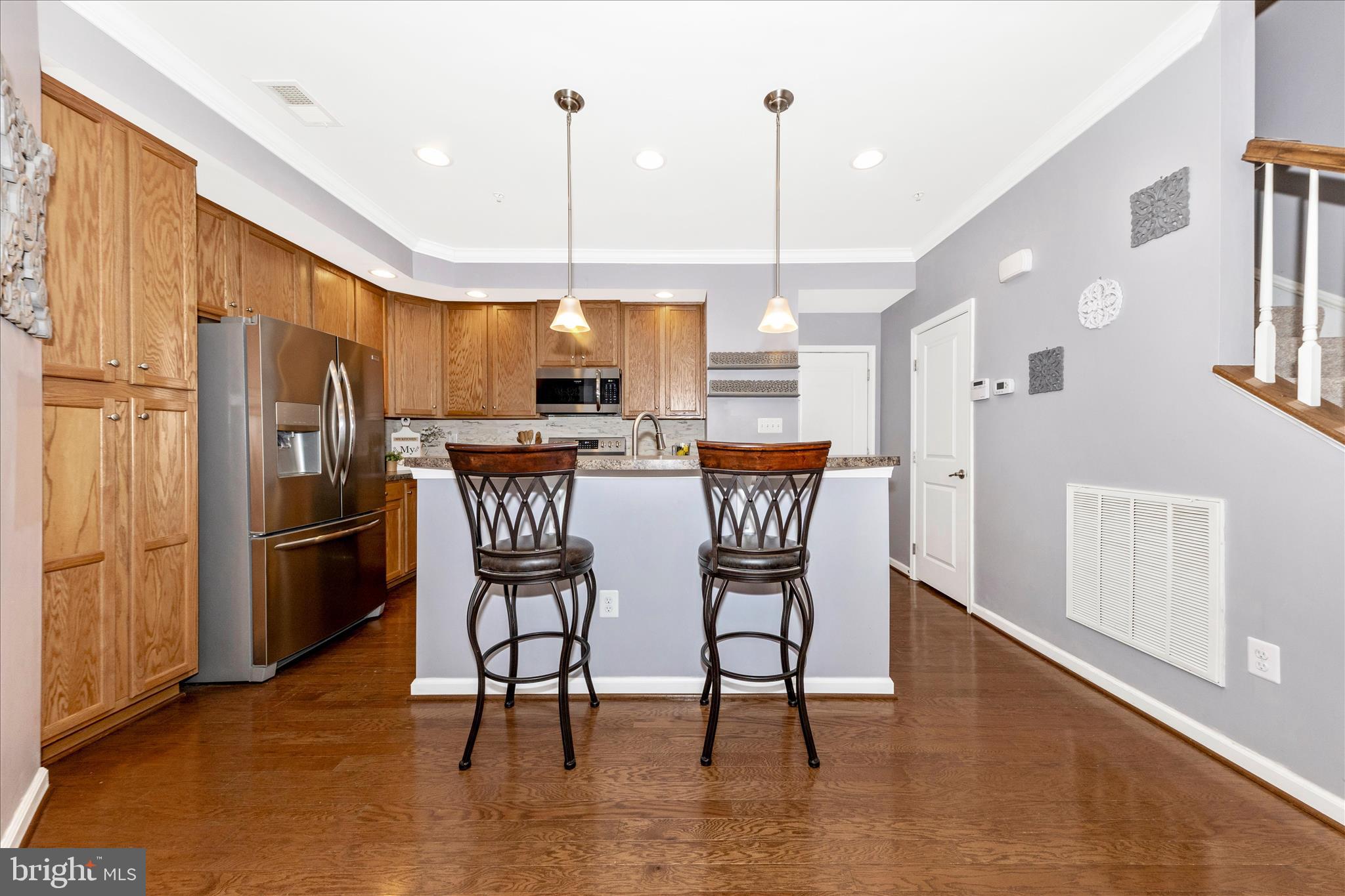 5043 Small Gains Way Frederick, MD 21703 - Photo 7 of 44 a kitchen with stainless steel appliances a dining table chairs stove and refrigerator