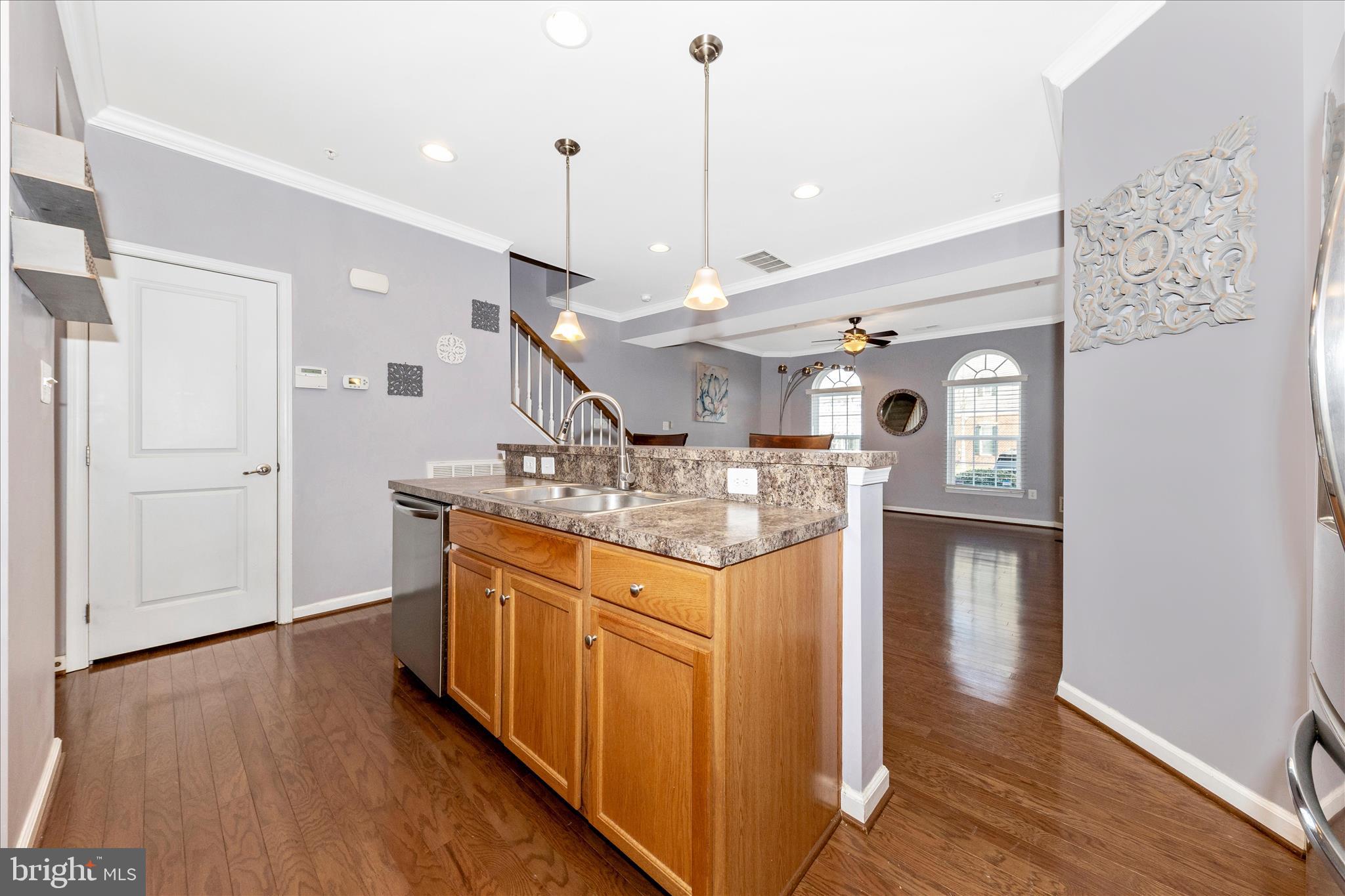5043 Small Gains Way Frederick, MD 21703 - Photo 9 of 44 a kitchen with stainless steel appliances granite countertop a sink a refrigerator and a wooden floor