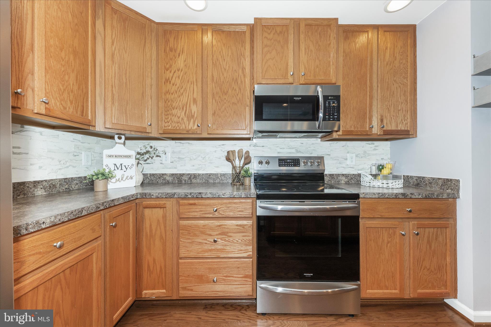 5043 Small Gains Way Frederick, MD 21703 - Photo 10 of 44 a kitchen with stainless steel appliances granite countertop a stove microwave and sink
