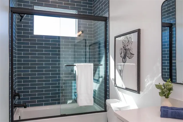 a bathroom with a shower toilet and a window