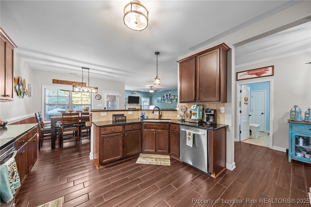 667 St Johns Loop Raeford, NC 28376 - Photo 15 of 50 a kitchen with stainless steel appliances granite countertop hardwood floor sink stove dining table and chairs