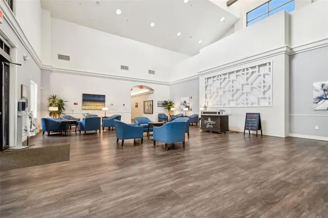 a dining hall with stainless steel appliances lots of white furniture a window and a rug