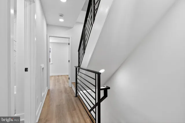 a view of a hallway with wooden floor and staircase
