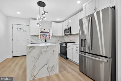a kitchen with kitchen island a counter top space stainless steel appliances and cabinets