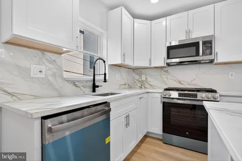 a kitchen with stainless steel appliances granite countertop a sink stove and microwave
