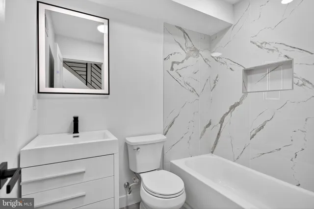 a bathroom with a toilet sink and mirror