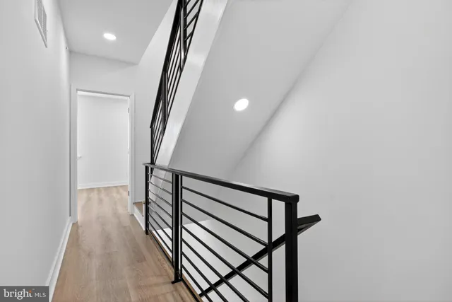 a view of a hallway with wooden floor and stairs