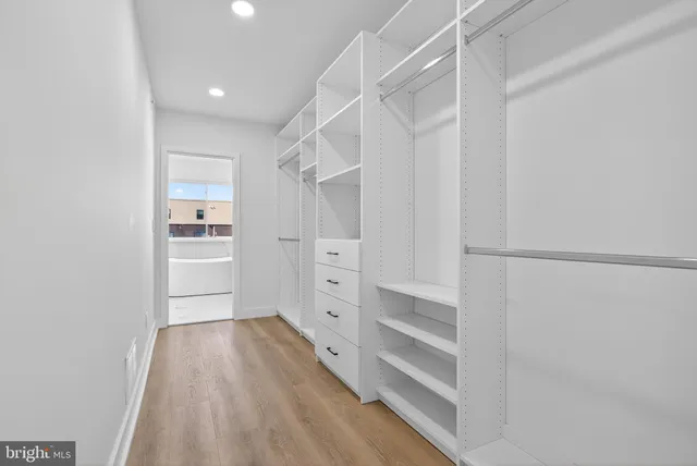 a view of walk in closet with empty racks