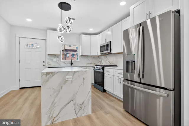 a kitchen with kitchen island a counter top space stainless steel appliances and cabinets