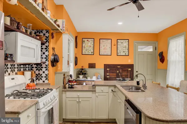 a kitchen with stainless steel appliances granite countertop a sink stove and cabinets