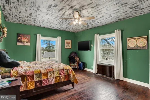 a bedroom with a bed table closet and flat screen tv