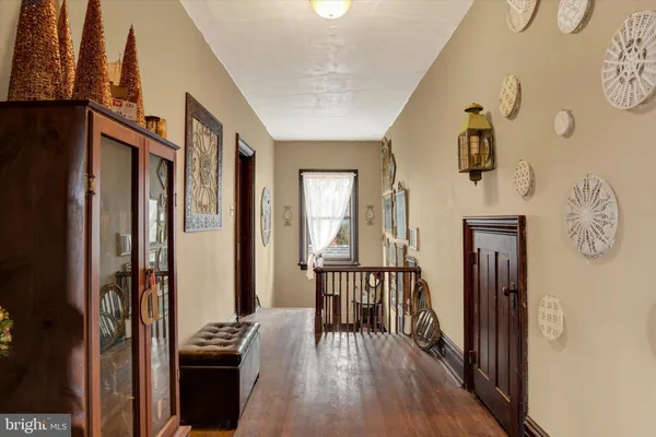 a view of a hallway with wooden floor and a livingroom