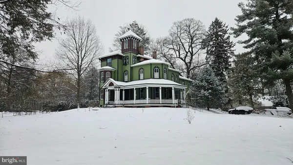 a front view of a house with a yard covered in snow