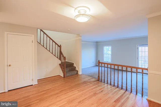 a view of a hallway with wooden floor and stairs