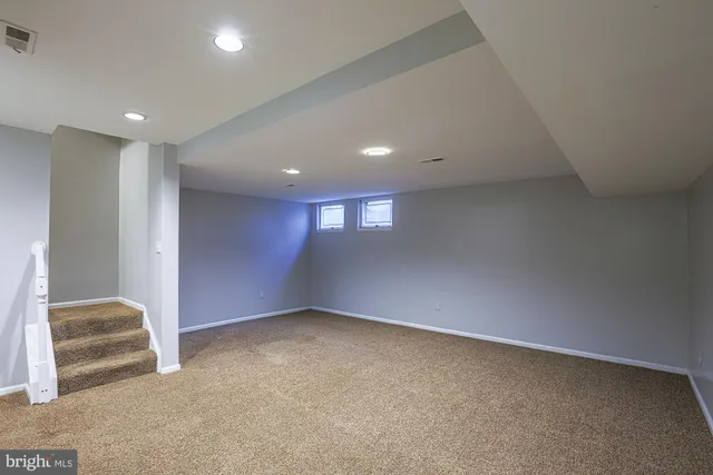 an empty room with windows and fireplace
