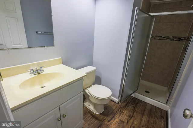 a bathroom with a granite countertop toilet a sink and shower