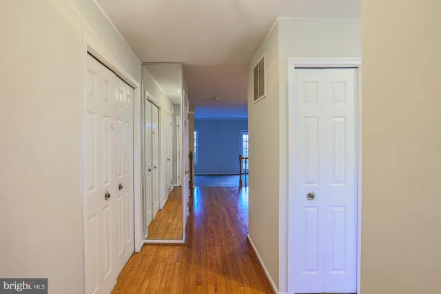 a view of a hallway with wooden floor and entryway