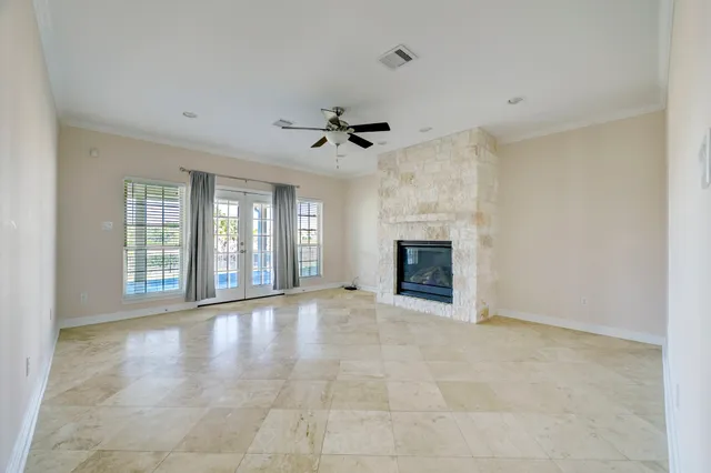 a view of an empty room with a fireplace and a window