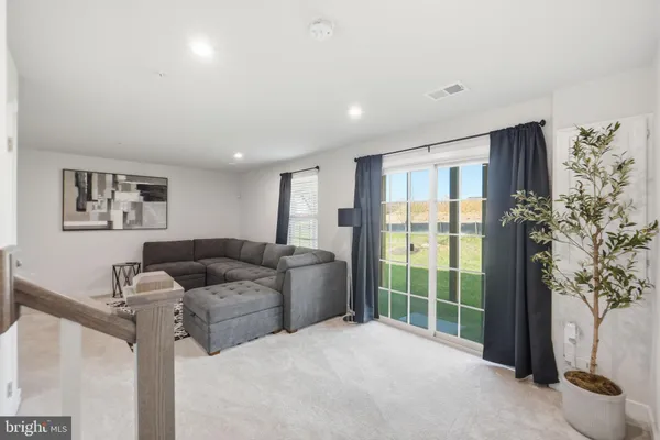 a living room with furniture and a floor to ceiling window