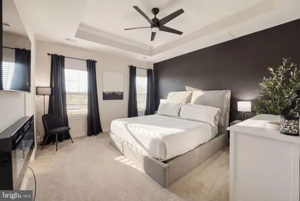 a bedroom with a bed and a flat tv screen on dresser