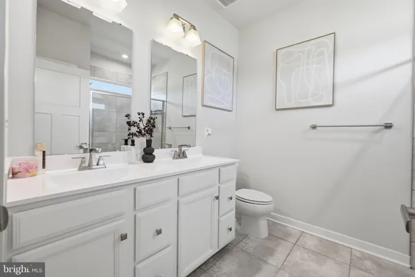 a bathroom with a double vanity sink mirror and toilet