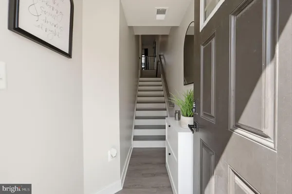 a view of a hallway with wooden floor and entryway