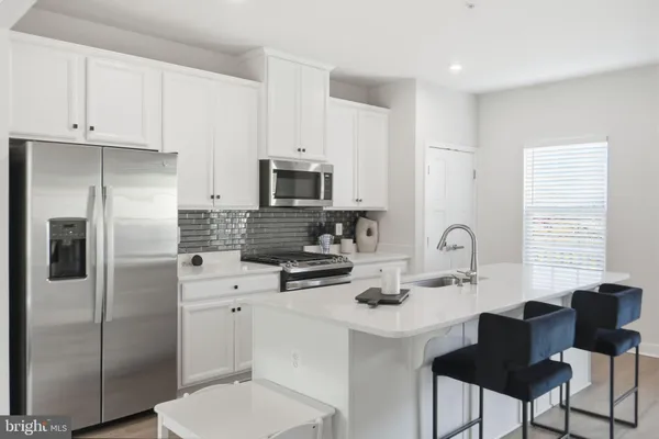 a kitchen with a refrigerator and a stove top oven
