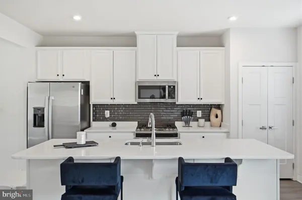 a kitchen with kitchen island granite countertop a sink stove and refrigerator