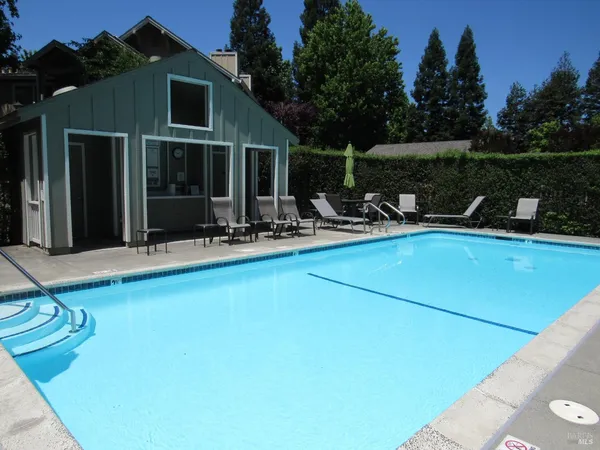 a view of a swimming pool with a lounge chair and tables