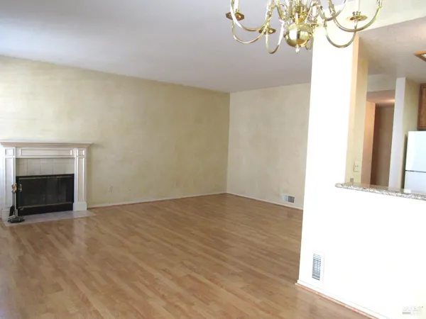 a view of empty room with wooden floor and fireplace