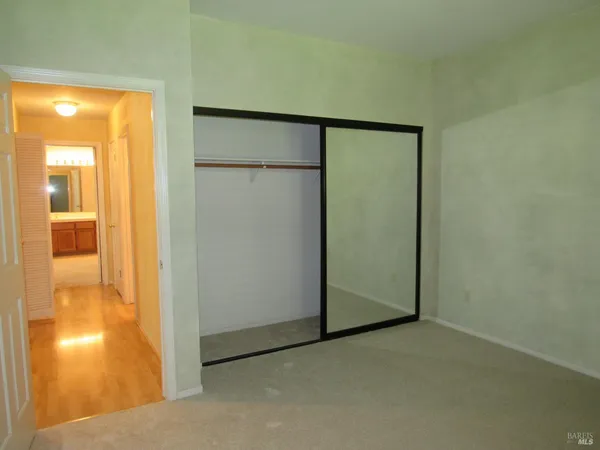an empty room with a bathroom and mirror