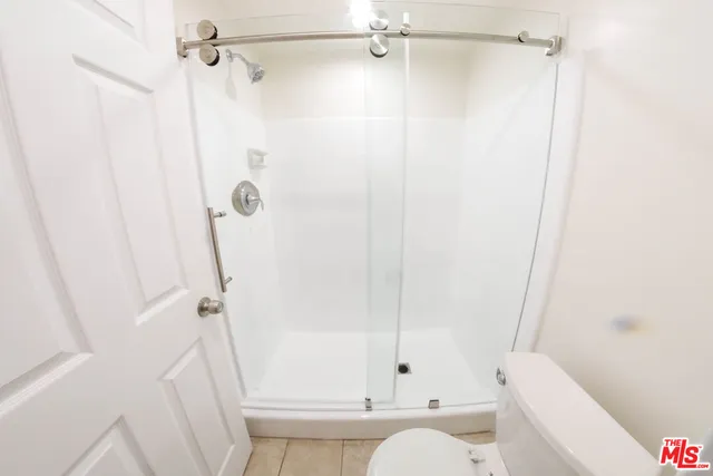 a bathroom with a bathtub shower and toilet